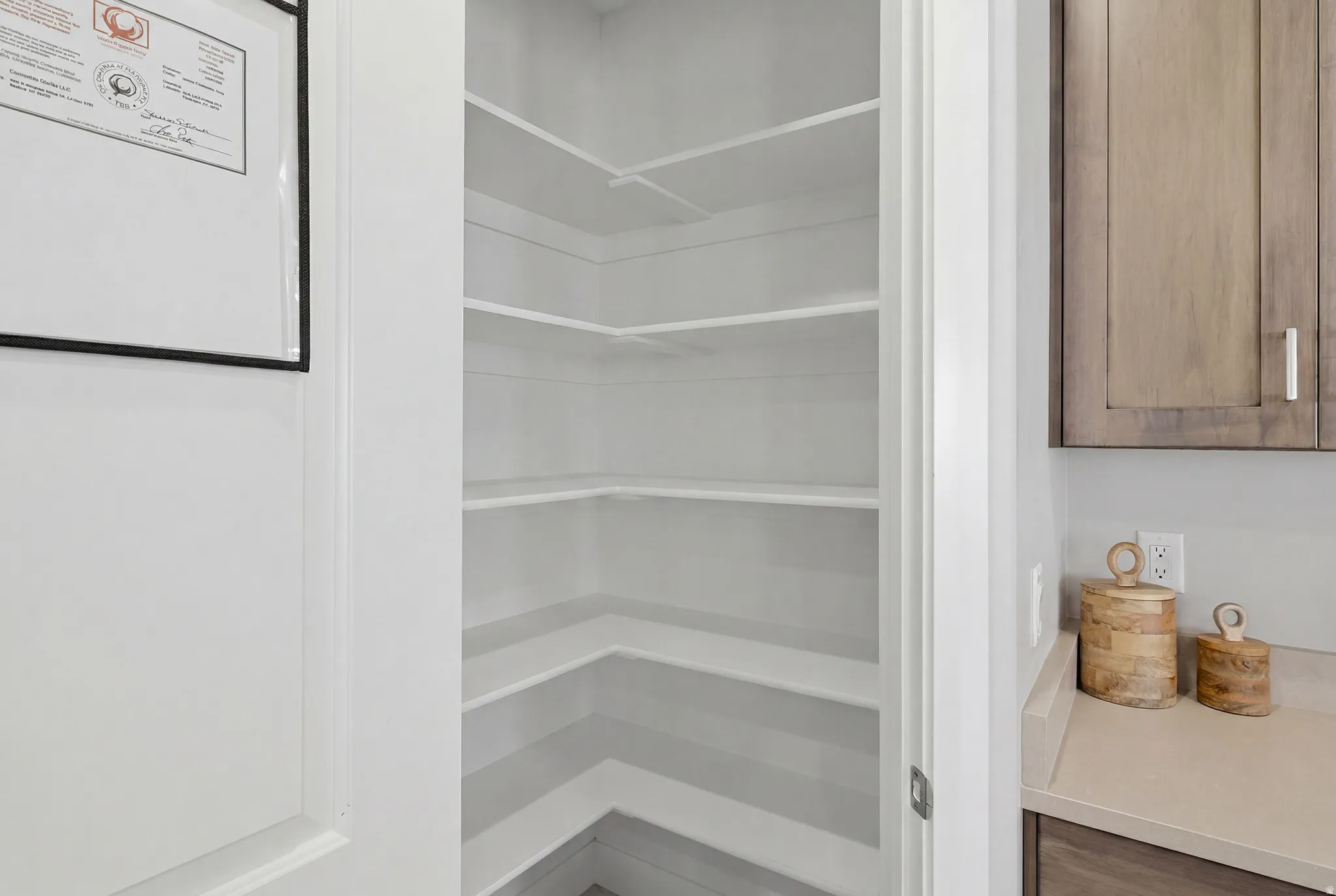 Walk-in pantry featuring multiple white built-in shelves