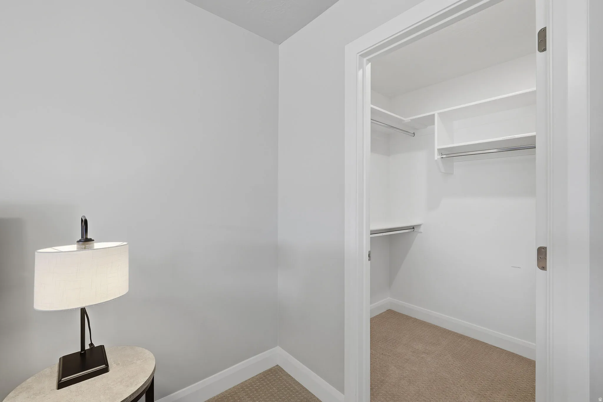 Walk-in closet with built-in shelving, multiple hanging rods, and carpet flooring