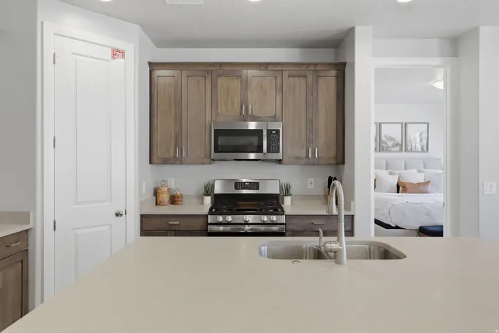 Kitchen featuring a large island with an undermount sink, stainless steel appliances, wood cabinetry, and recessed lighting