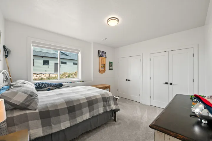 Recessed window with white trim, wall-to-wall carpeting, two sets of white double doors, and a flush mount ceiling light fixture