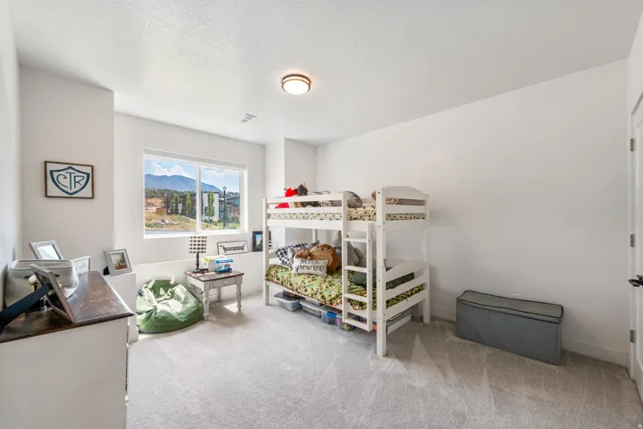 Spacious room featuring light gray carpeting, a large window, and a flush-mount ceiling light fixture