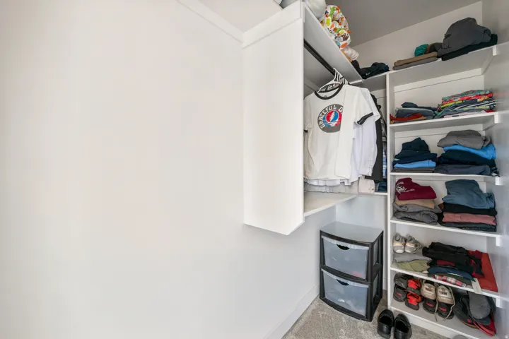 Built-in white shelving system with a hanging rod and open shelving