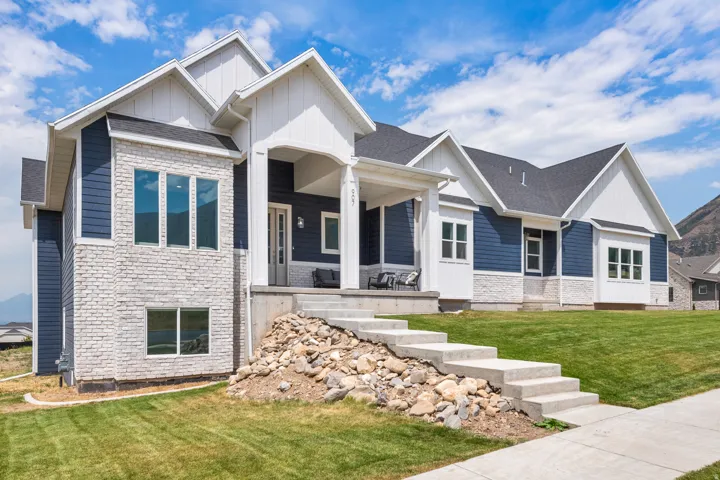 Contemporary exterior with blue siding and white trim, featuring a stone facade accent