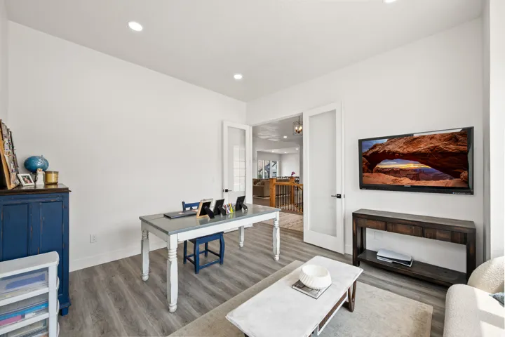 Recessed lighting illuminates wood-finish flooring