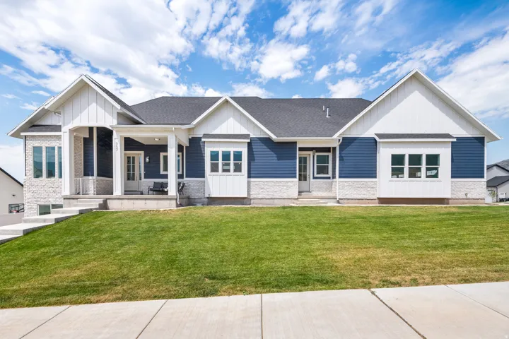 Contemporary exterior featuring blue siding, white board and batten accents, and light-toned stone detailing