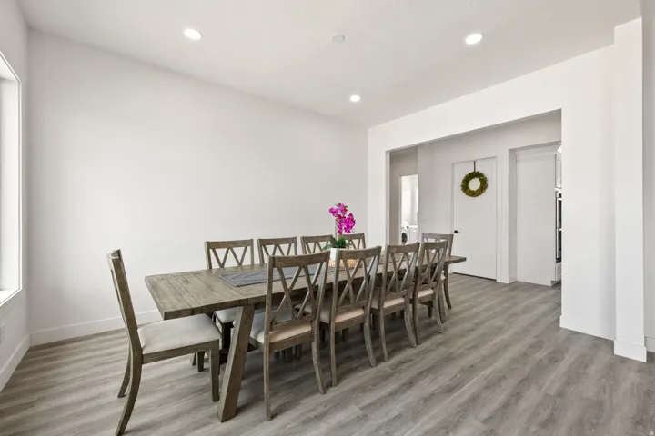 Recessed ceiling lighting, wood-finish flooring, white walls, and a window