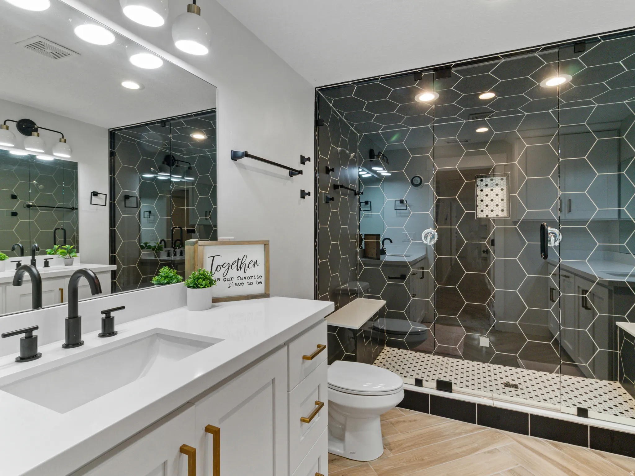 White vanity with gold-tone hardware, matte black faucets, and a rectangular undermount sink