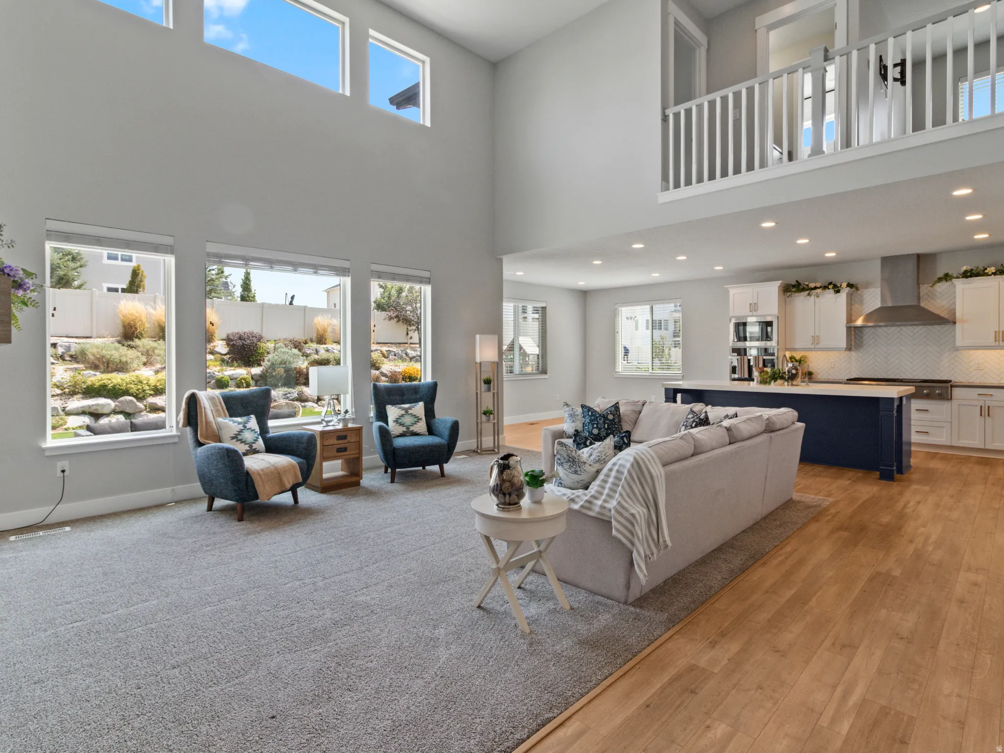 Double-height ceiling with clerestory windows, large picture windows, wood-finish flooring, recessed lighting, and an open-concept layout
