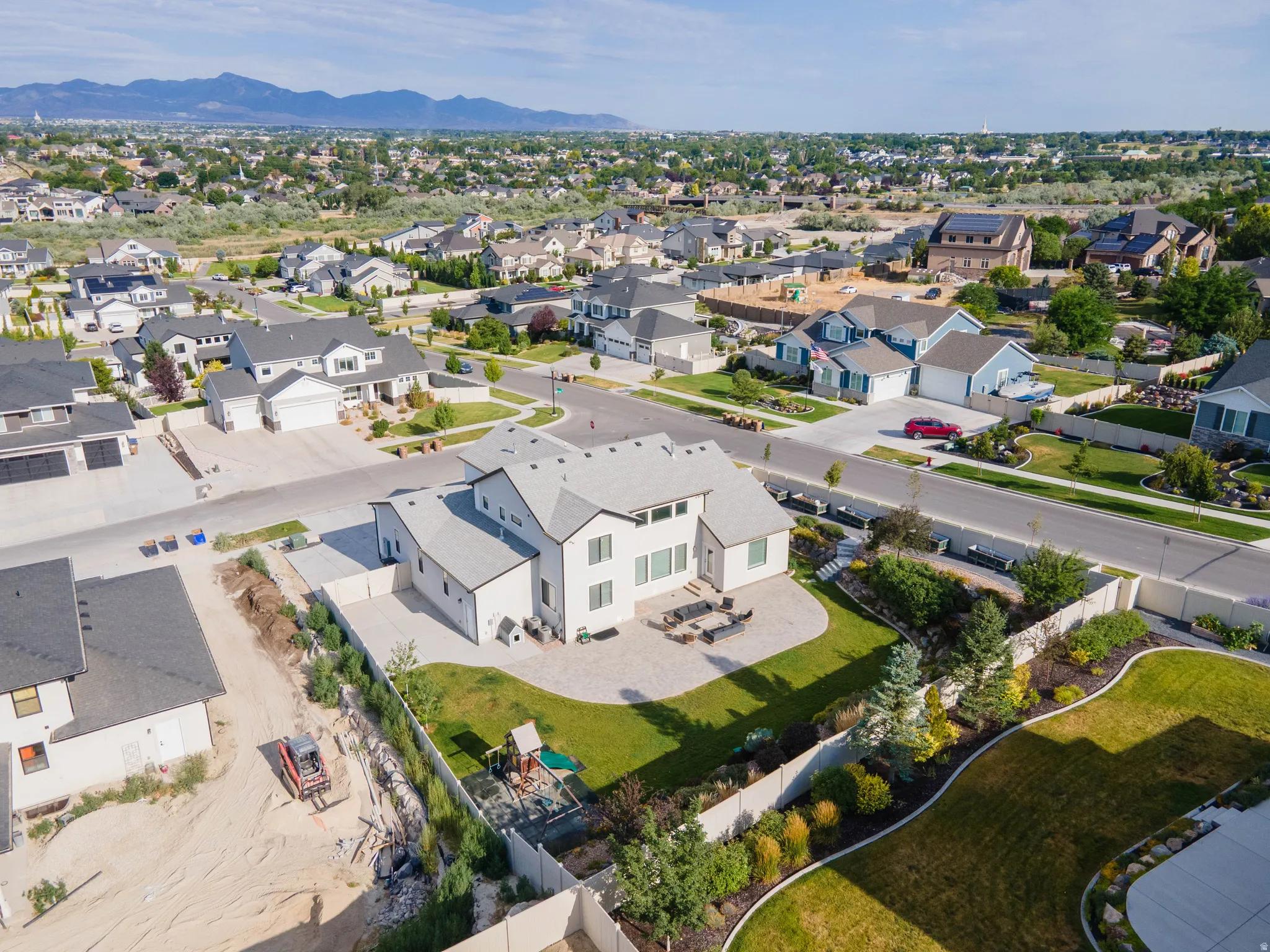 Spacious property featuring a large patio, manicured lawn, and mature landscaping
