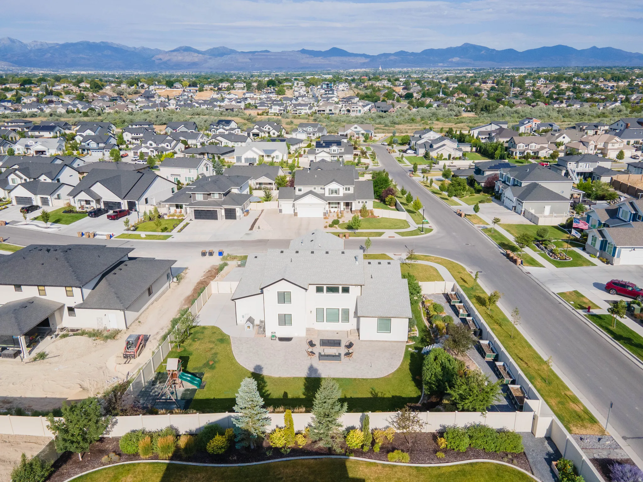 Expansive suburban neighborhood featuring a variety of single-family residences, paved streets, and mountainous scenery