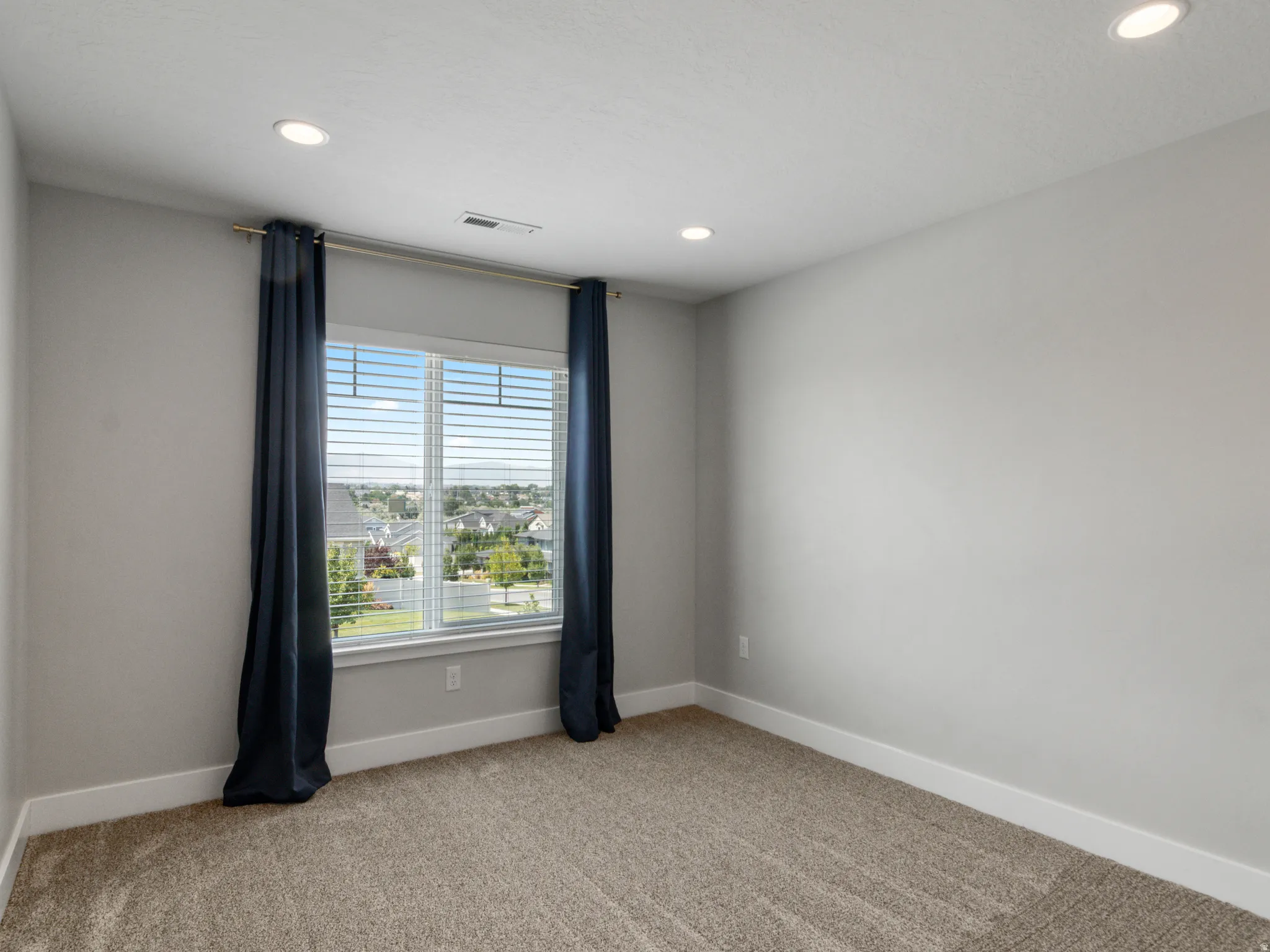 Recessed lighting, neutral wall tones, window with horizontal blinds, carpeting, and white trim