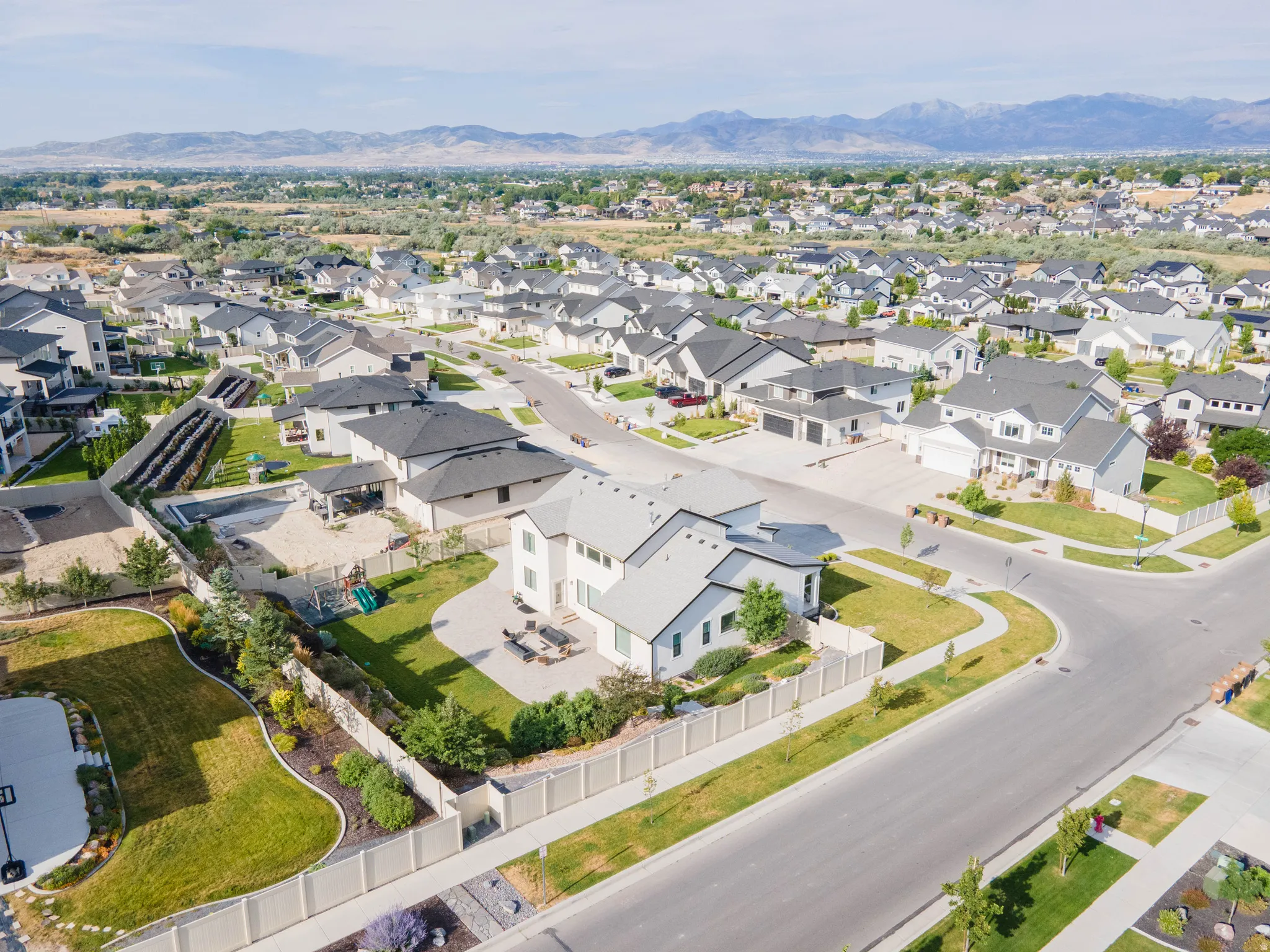 Contemporary neighborhood setting with paved streets, sidewalks, and residential fencing