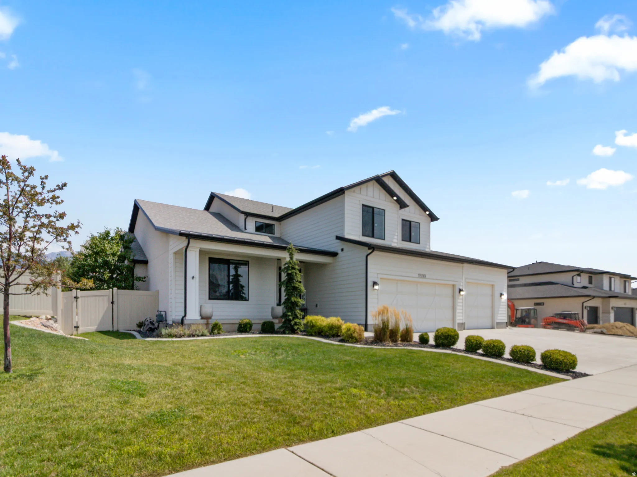 Modern two-story residence featuring a clean architectural design with peaked rooflines, composite siding exterior, and a 5-car attached garage