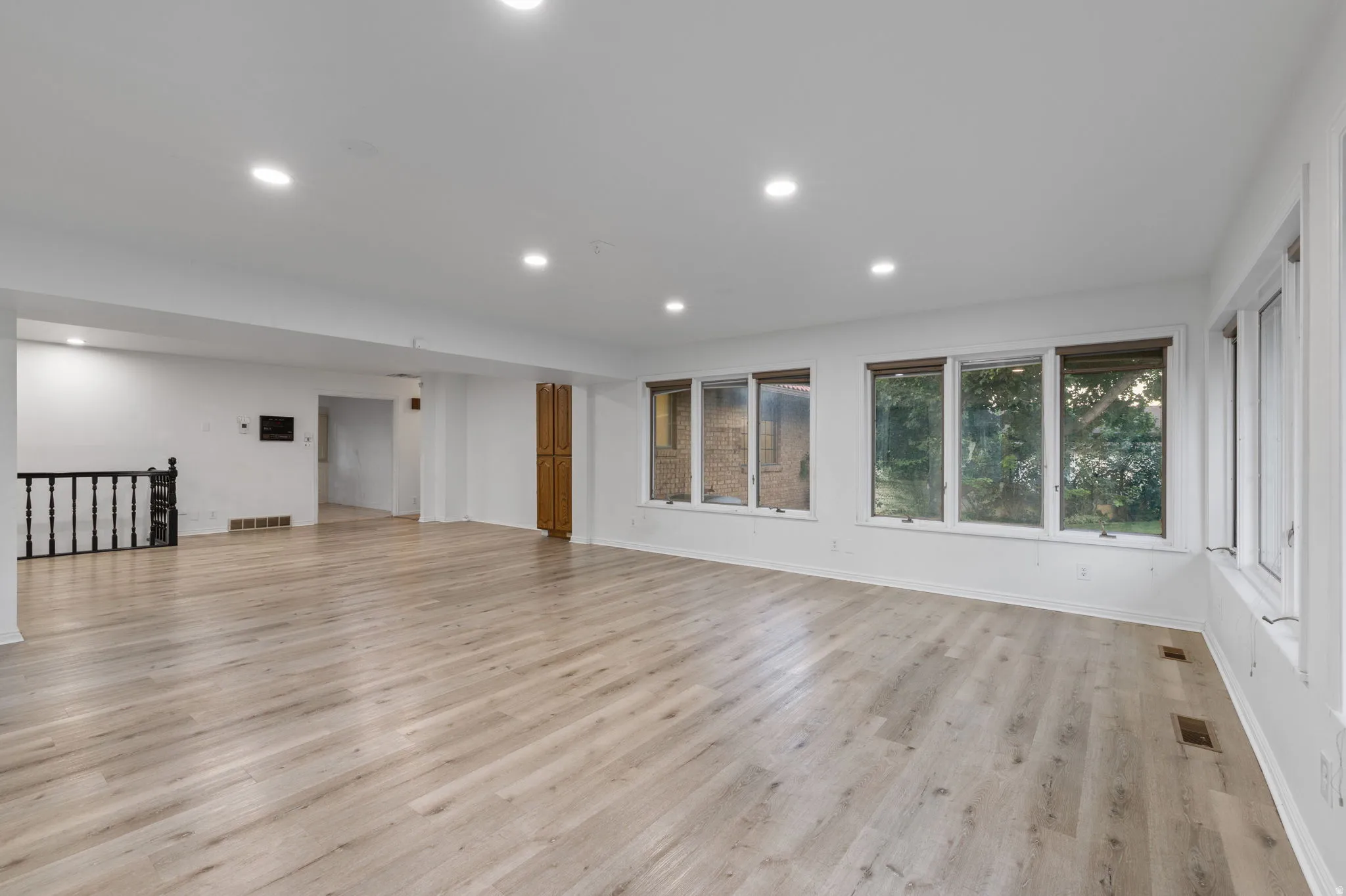 Spacious interior with wood-finish flooring, recessed lighting, and multiple windows