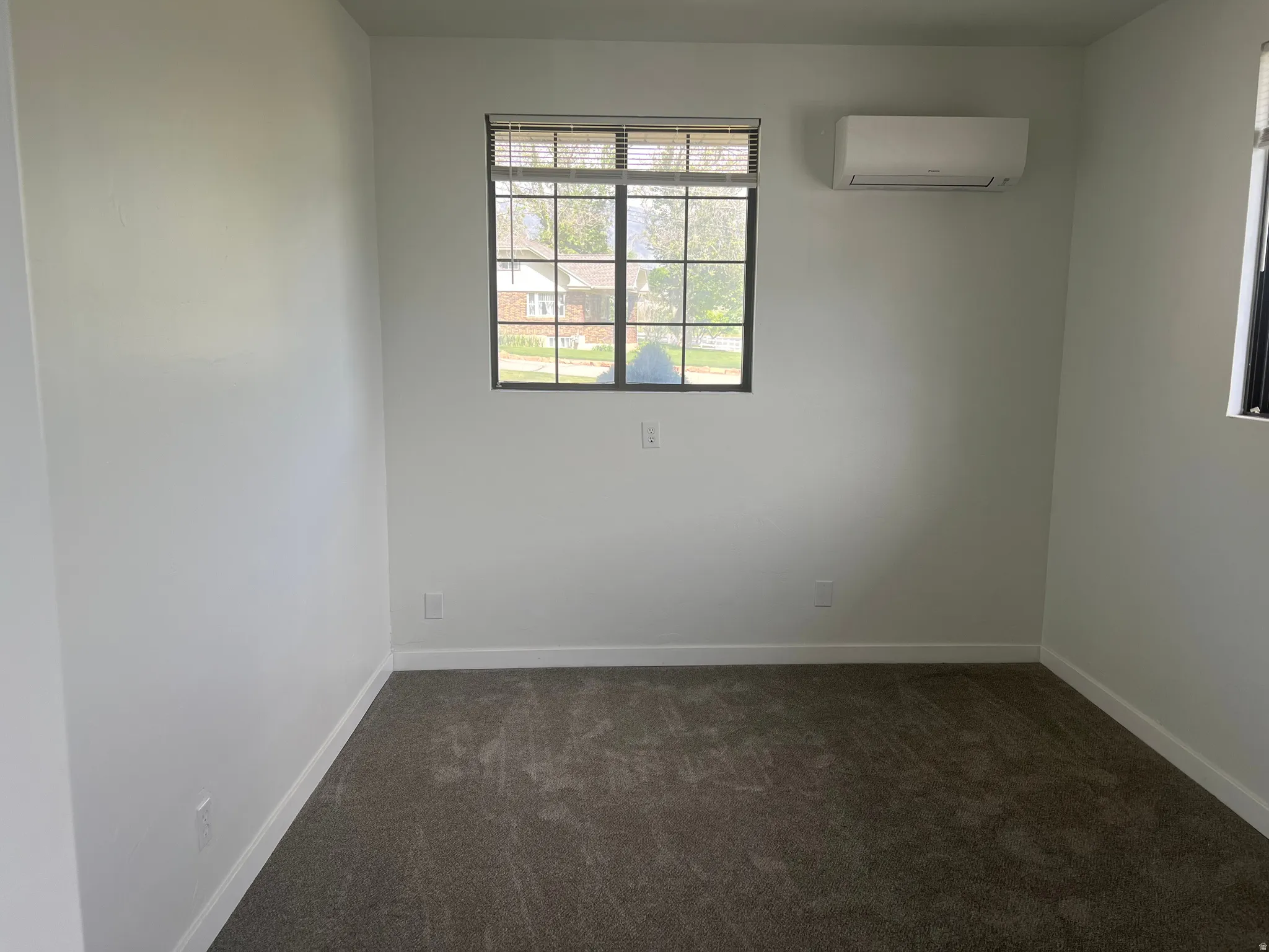 White painted walls with dark gray carpeting