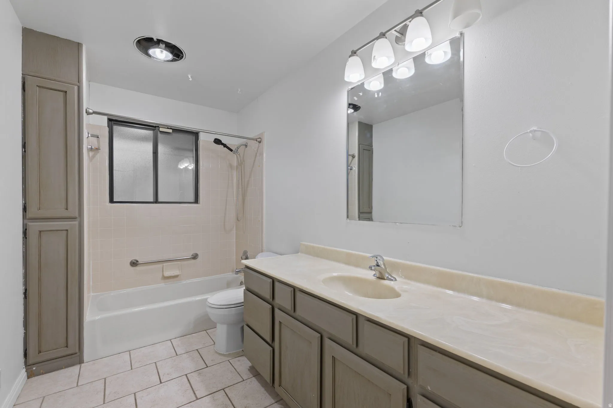 Bathroom with a single vanity, integrated sink, and an overhead light fixture