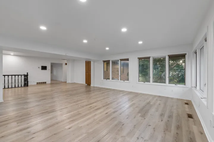 Spacious interior with wood-finish flooring, recessed lighting, and multiple windows