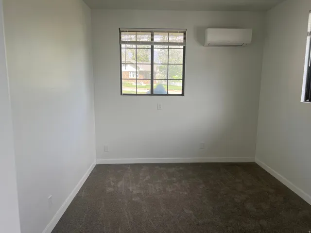 White painted walls with dark gray carpeting