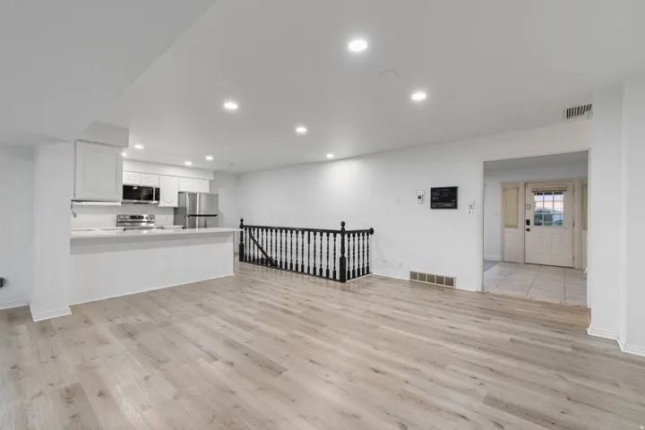 Contemporary kitchen with white cabinetry, stainless steel appliances, and a breakfast bar