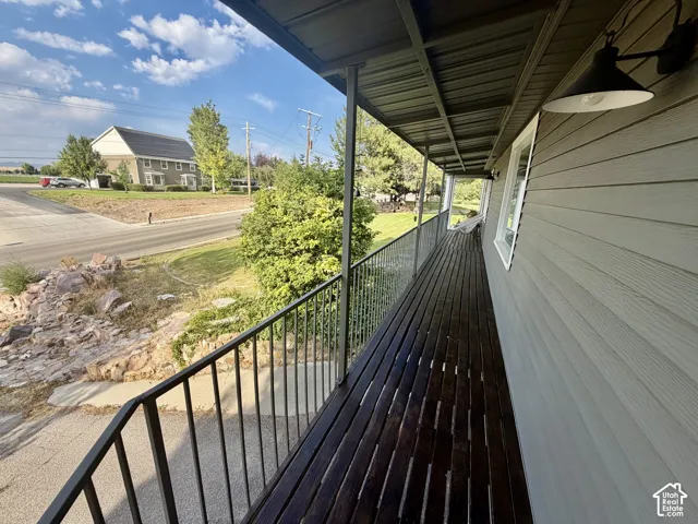 Expansive covered porch with wood-finish decking and dark metal railings