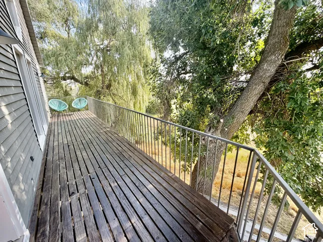 Expansive wood deck with metal railings and mature trees