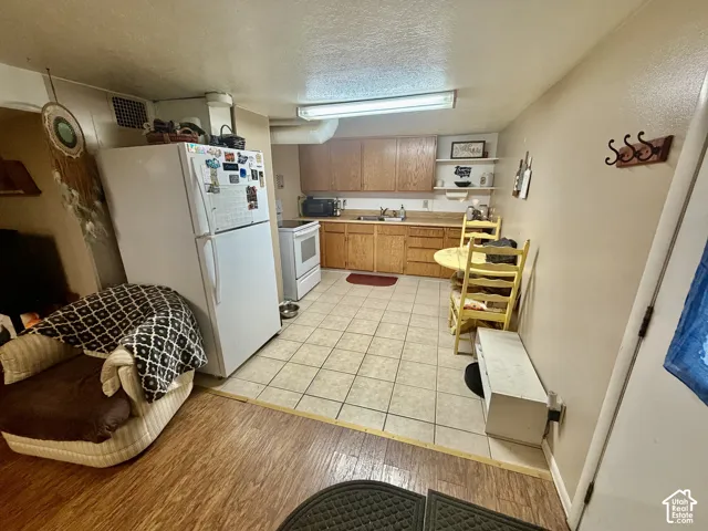 Kitchen featuring wood-finish cabinetry, tile flooring, and a stainless steel sink