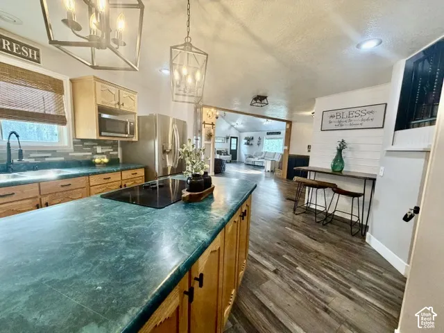 Kitchen featuring wood cabinetry, green countertops, and a built-in cooktop