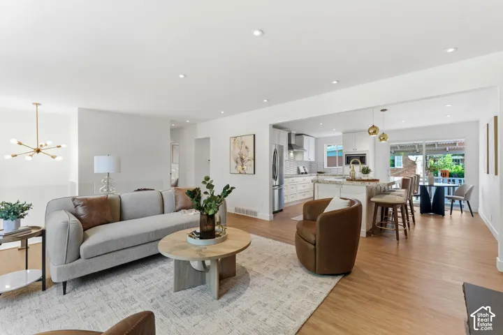 Open-concept living space with recessed lighting, wood-finish flooring, and white walls