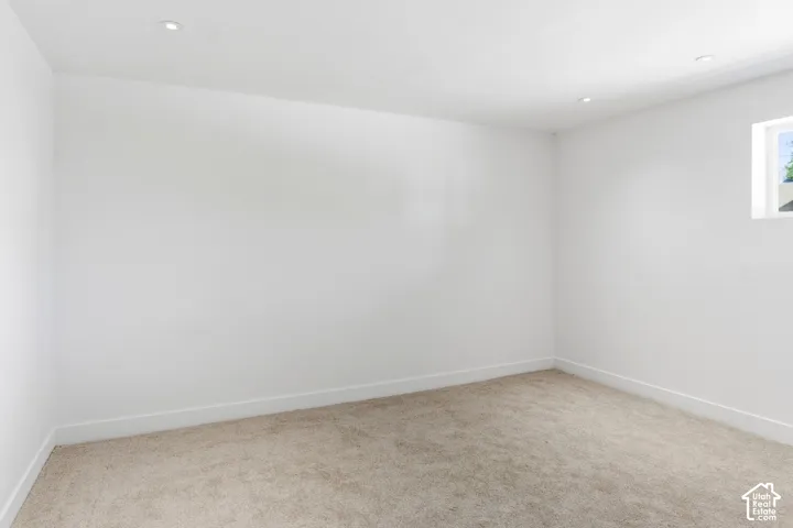 Recessed lighting, white walls, light-toned carpet flooring, single window