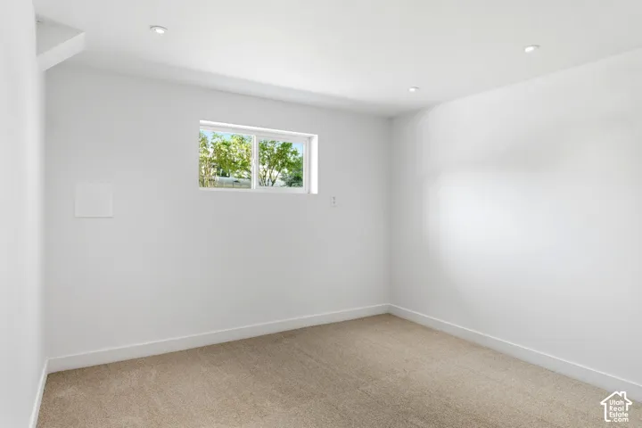 Recessed ceiling lighting, white painted walls, and neutral carpeting