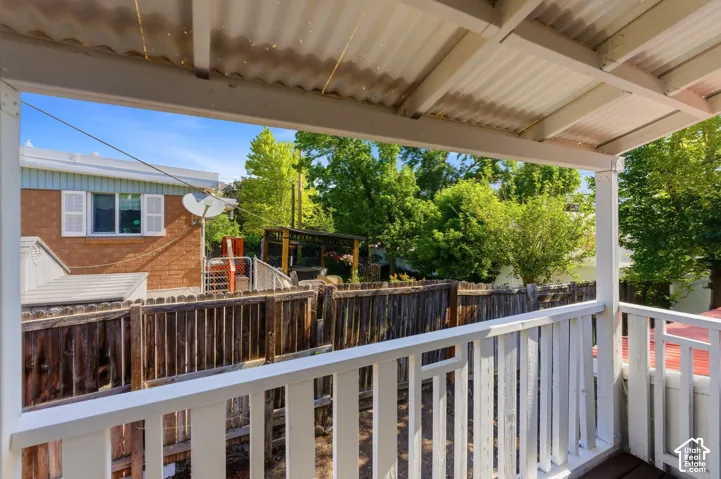 Covered outdoor deck with white railing and corrugated roof