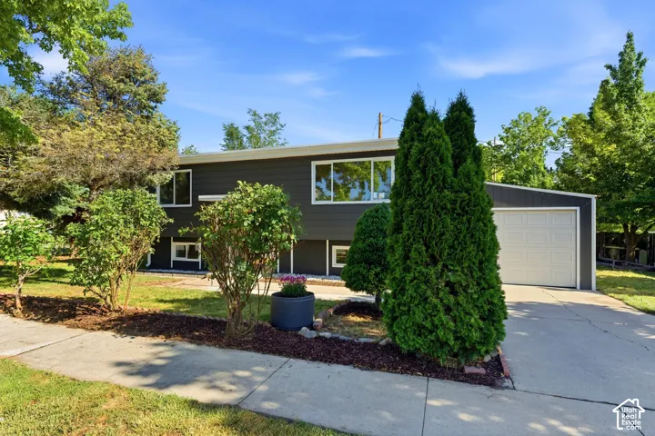 Contemporary exterior with dark siding, white trim, and a prominent attached garage