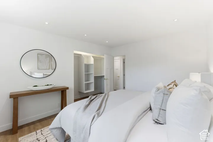 Recessed ceiling lighting, wood-finish flooring, built-in shelving, and a solid core interior door