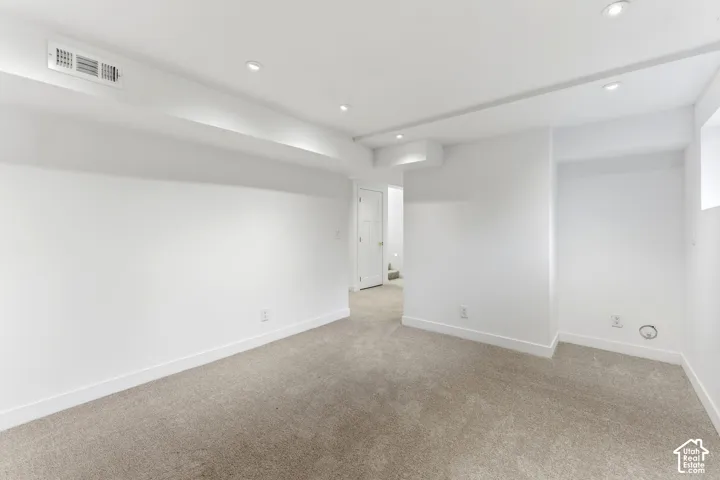 Recessed ceiling lighting, light-toned carpeting, white walls, and white trim