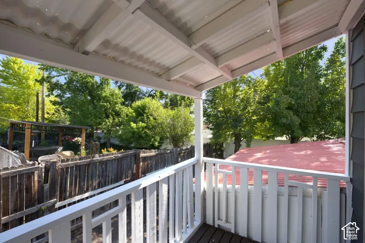 Covered outdoor porch with wood flooring and white railing
