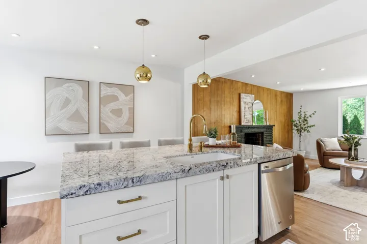 Kitchen island with a light-toned countertop, integrated sink, and gold-finish faucet