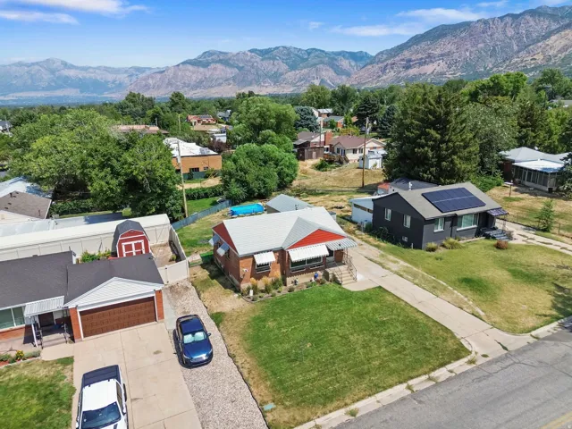 Red brick exterior with a white roof and matching awnings, complemented by a manicured lawn