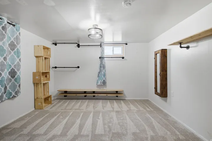 Spacious room featuring polished concrete flooring with linear design detail, white walls, and abundant natural light from multiple windows