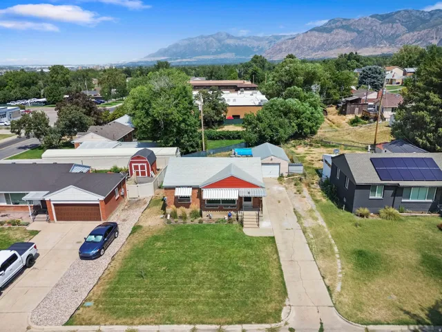 Property featuring a mountain backdrop, mature trees, and a detached garage