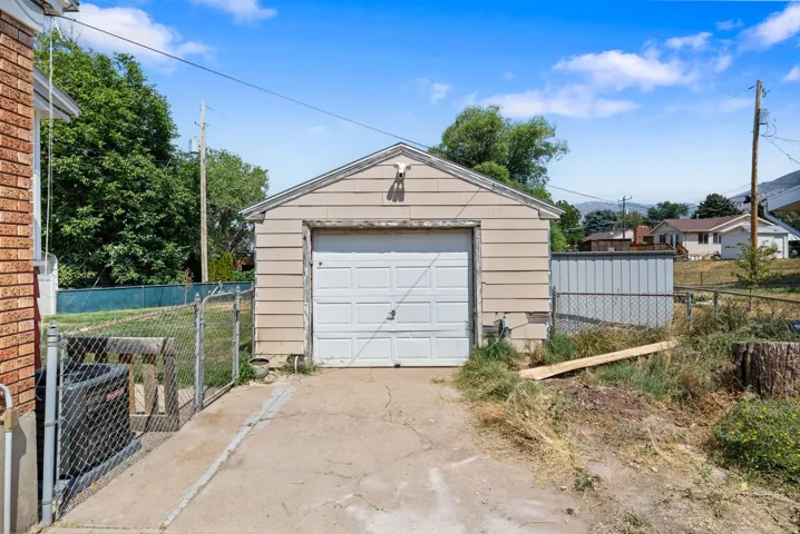 Detached garage with a paneled door, offering convenient parking and additional storage