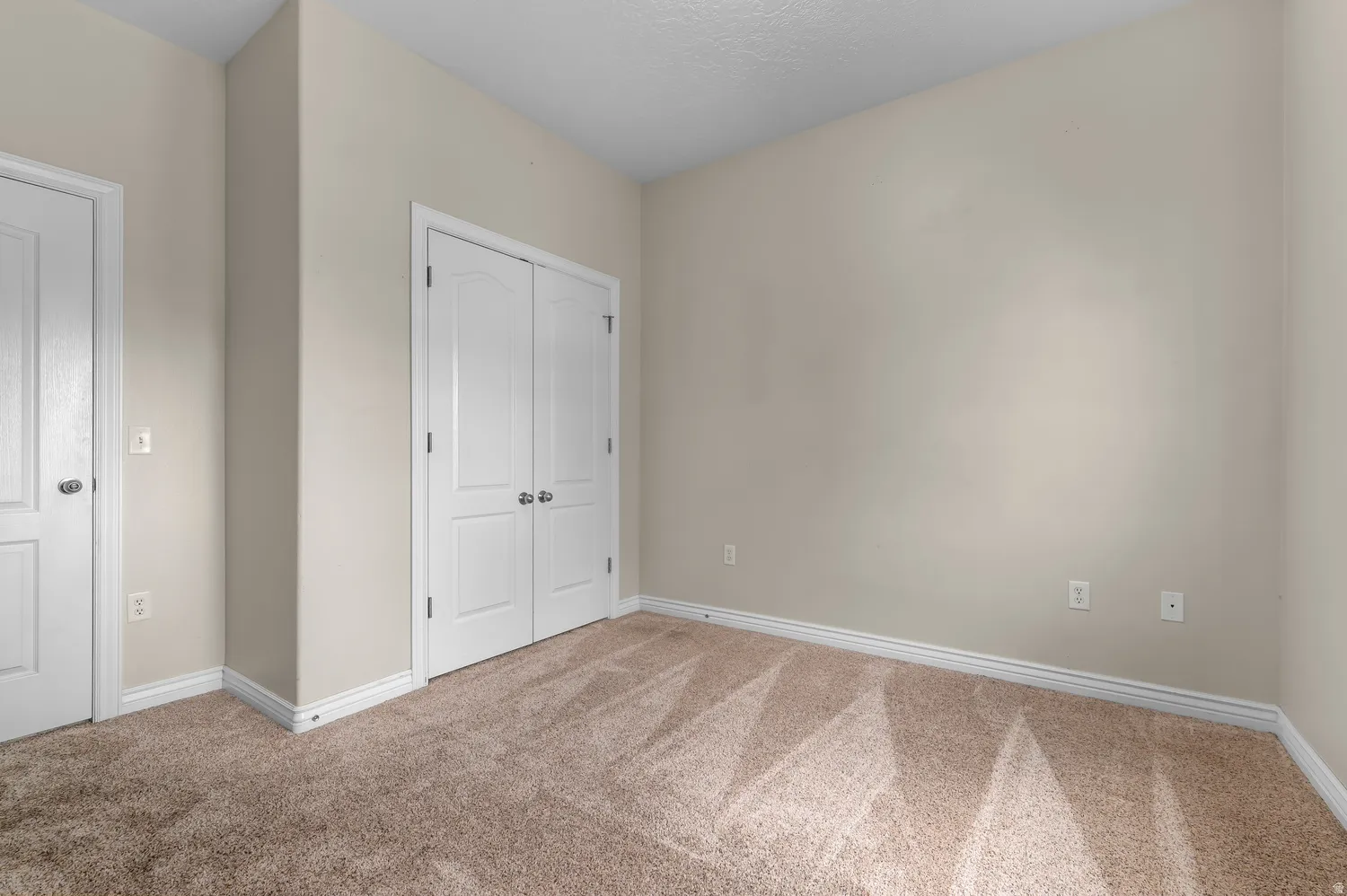 Neutral-toned walls with light brown carpeting