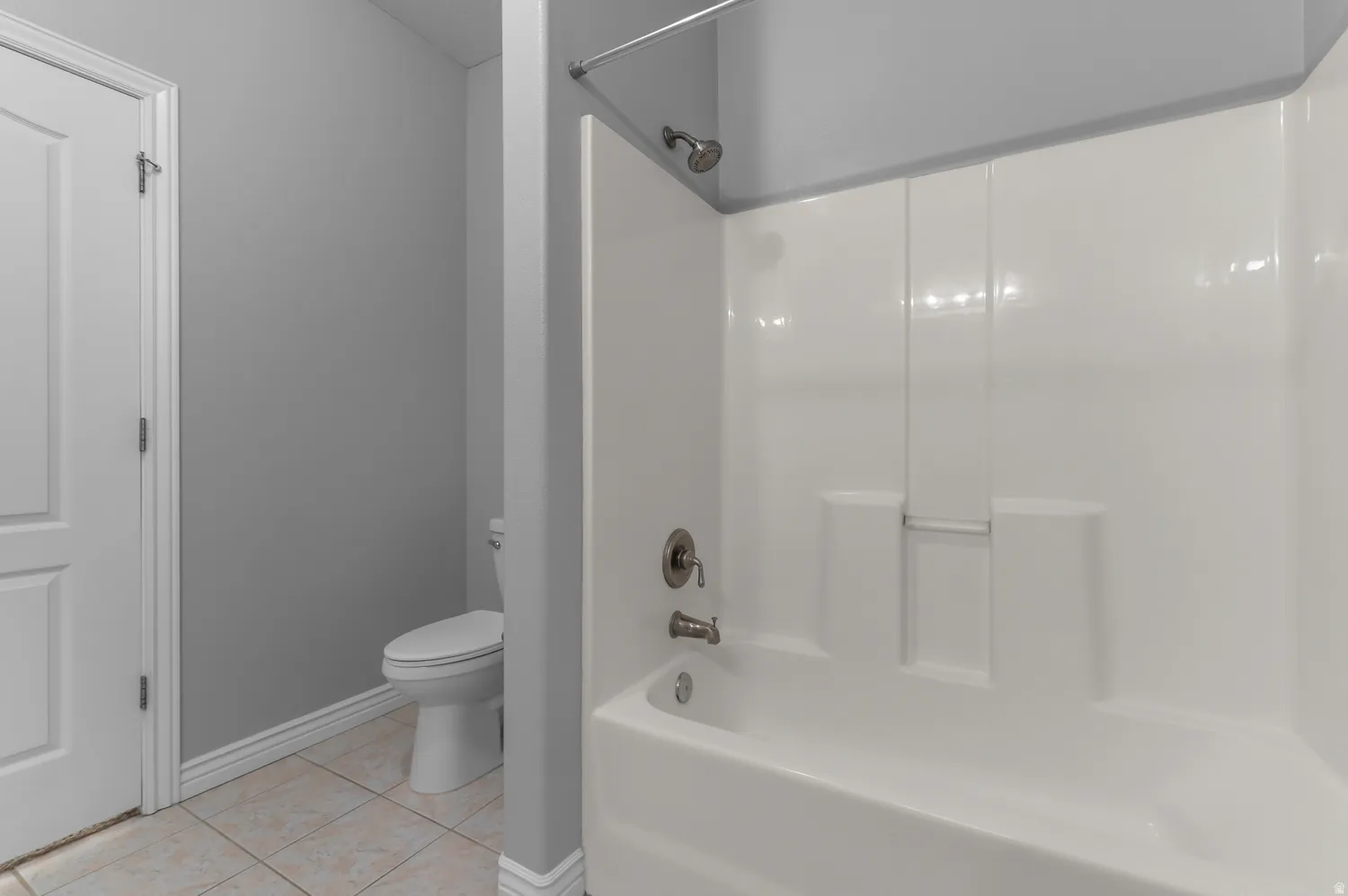 White tub and shower combination with brushed nickel fixtures