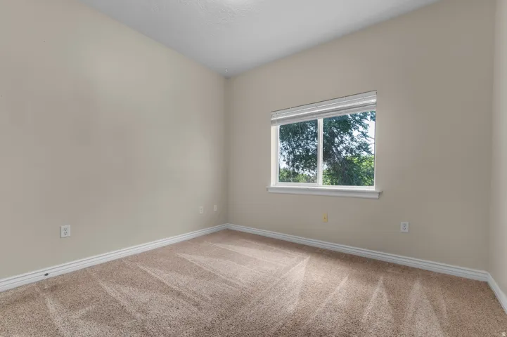 Wall-to-wall carpet flooring, neutral paint palette, and a window with horizontal blinds