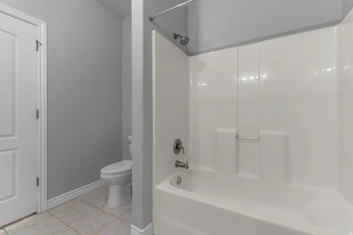 White tub and shower combination with brushed nickel fixtures