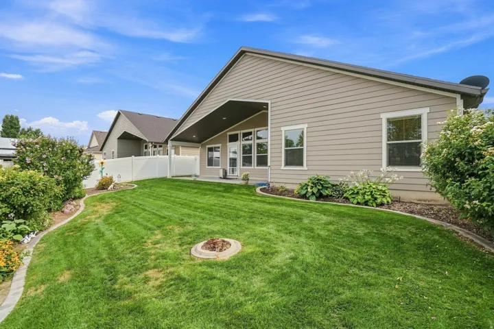Expansive green lawn, mature landscaping, and an outdoor fire pit