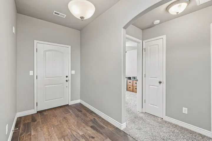 Entryway featuring wood-finish flooring, light gray wall paint, and white trim