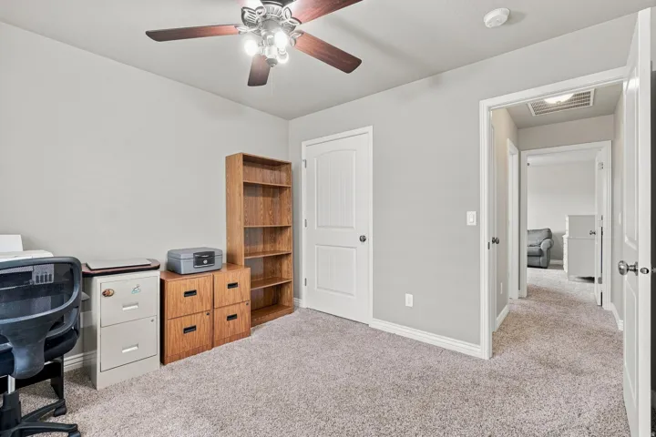 Neutral wall paint, ceiling fan with light fixture, white trim, and light-colored carpet