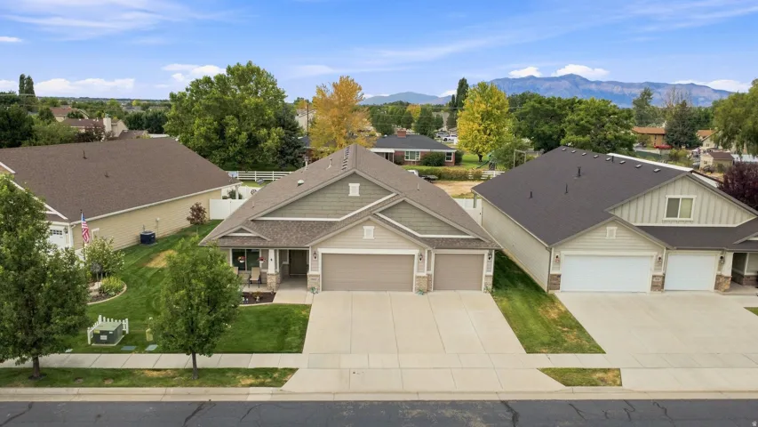 Residence featuring a stone and siding exterior, a two-car garage, and a concrete driveway