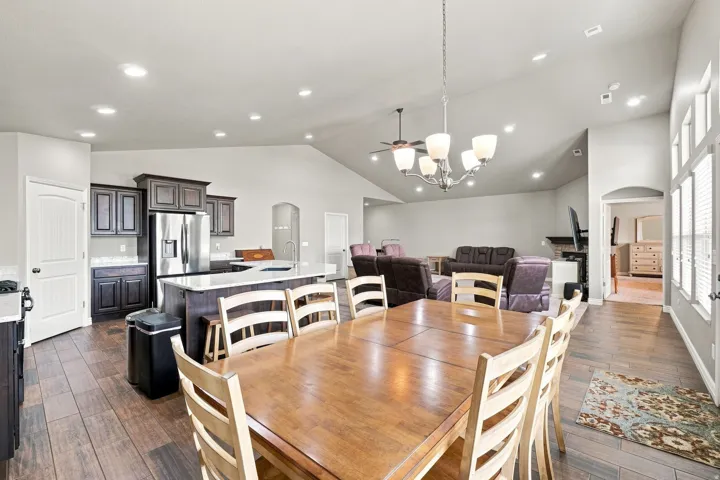 Vaulted ceilings, wood-finish flooring, recessed lighting, and a kitchen island with seating