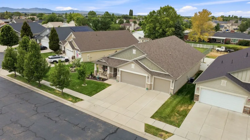 Single-story residence featuring a covered front porch, dual garage doors, and a paved driveway